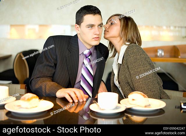 Man and Woman at the Bar. Short Depth of Focus (On Their Faces). Woman's wispering to man's ear