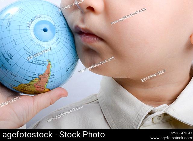 Baby holding a small globe in hand on white background