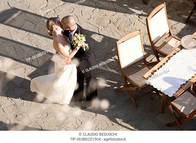 Italy, Liguria, Cinqueterre, Monterosso, bride and groom kissing