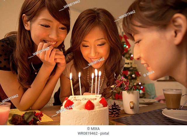 Three Young Women Looking at Christmas Cake