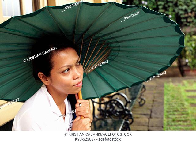 Asian woman holding a paper made umbrella at Losari Coffee Plantation in West Java, Indonesia, South East Asia