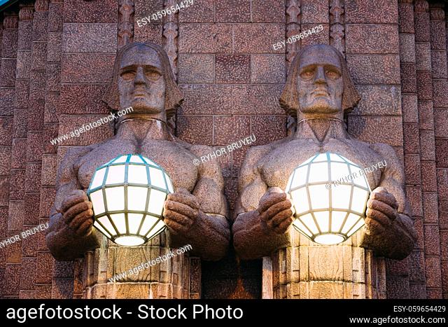 Helsinki, Finland. Night View Of Two Pairs Of Statues Holding The Spherical Lamps On Entrance To Helsinki Central Railway Station