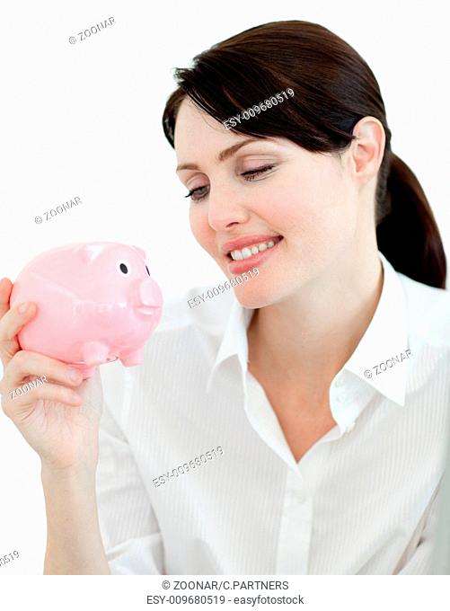 Attractive businesswoman looking at a piggybank