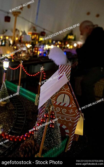 PRODUCTION - 05 December 2023, Bavaria, Coburg: Horst Gründel sits in the middle of his miniature Christmas market measuring around eight square meters