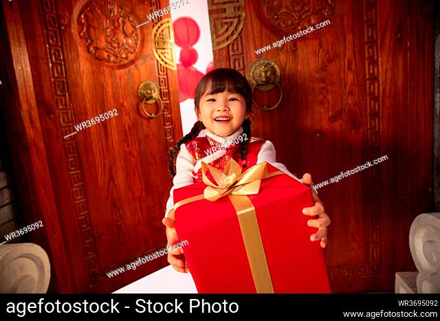 New Year's lovely little girl holding a gift box
