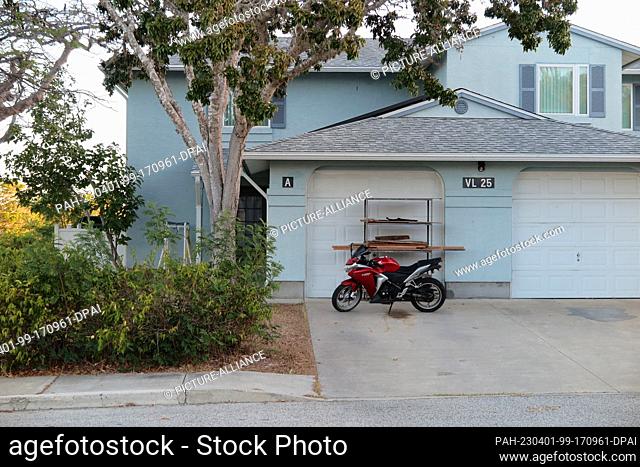 PRODUCTION - 15 January 2023, Cuba, Guantánamo: A red motorcycle stands in front of a residential building at the naval base in Guantánamo Bay, Cuba