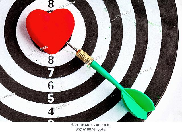 Black white target with dart in heart love symbol as bullseye