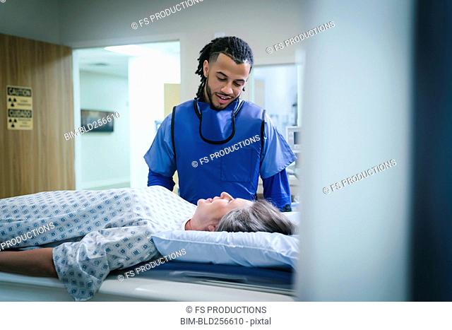 Technician talking to patient near scanner