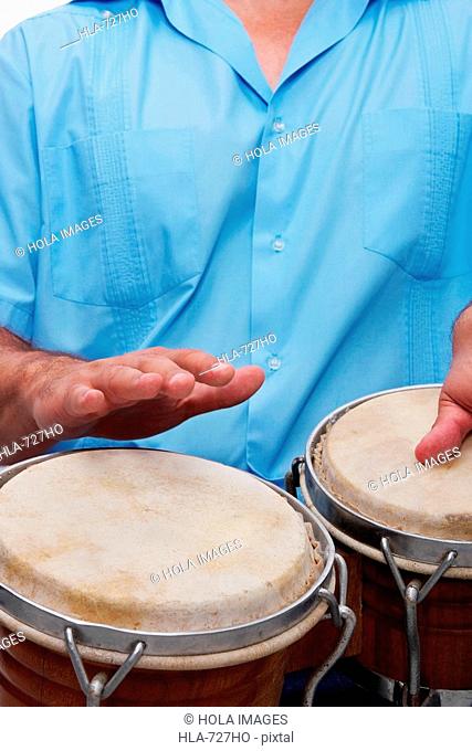 Mid section view of a man playing bongo drums