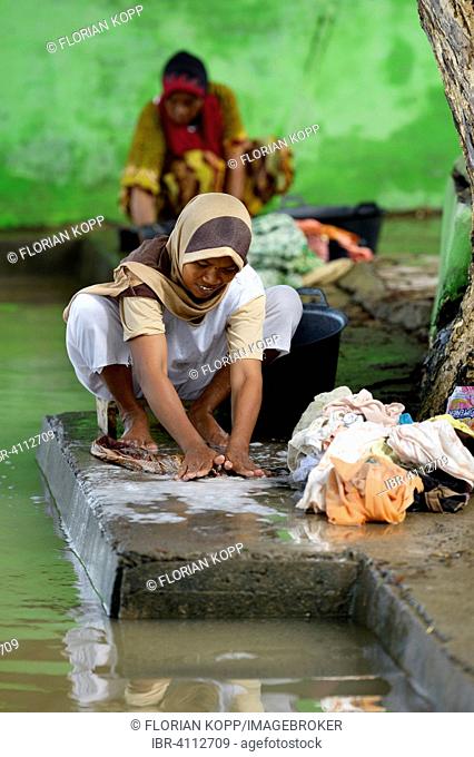 Woman washing laundry by the river, Nusa Gampong village, Aceh, Indonesia
