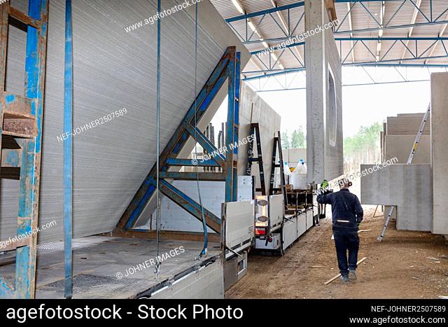 Worker sorting concrete segments in warehouse
