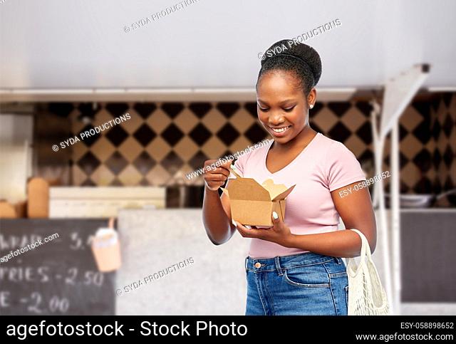 happy woman eating wok over food truck