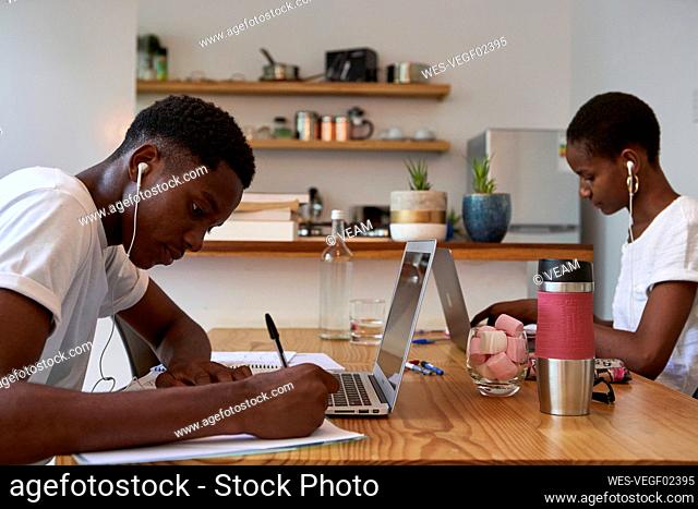 Young couple studying on table at home