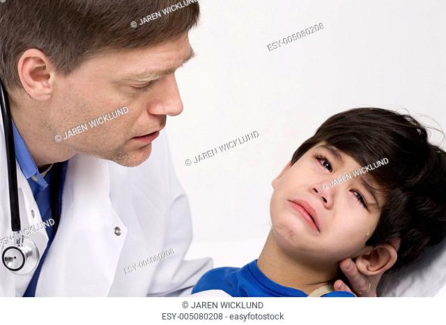Male doctor comforting disabled toddler patient. Child is five years old