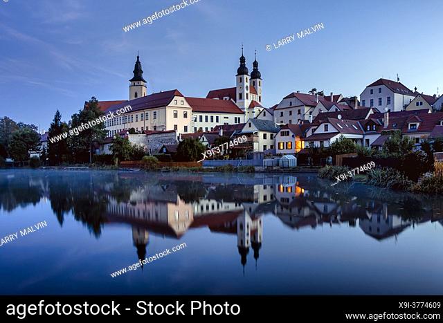 Early morning view of the Telc castle with foreground pond and reflections in the Czech Republic