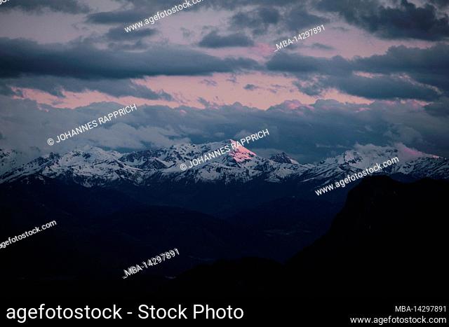 mountainous landscape with sunlit peak during sunset. cloudy mood