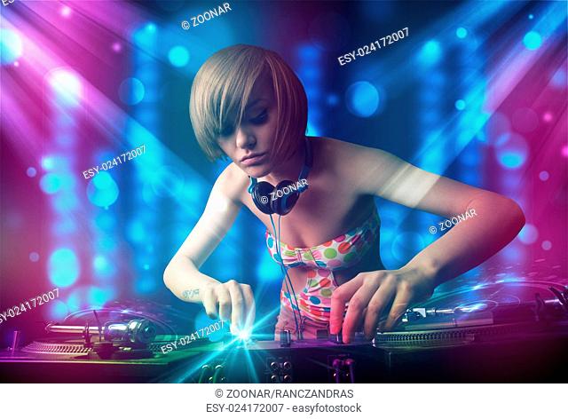 Dj girl mixing music in a club with blue and purple lights