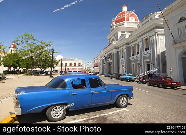 Old American car parked in the street in Jose Marti Park in front of the Governer's House-Palacio del Gobierno, Cienfuegos, Cienfuegos Province, Cuba