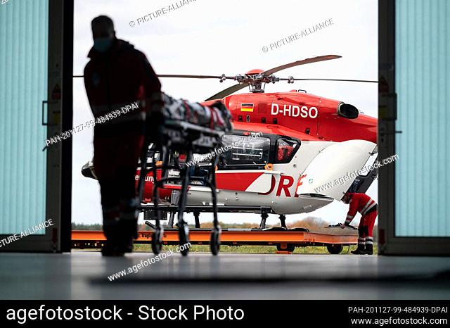 19 November 2020, Baden-Wuerttemberg, Rheinmünster: Patrick Bierherr, emergency paramedic, pushes a stretcher in the hangar of the intensive care helicopter...