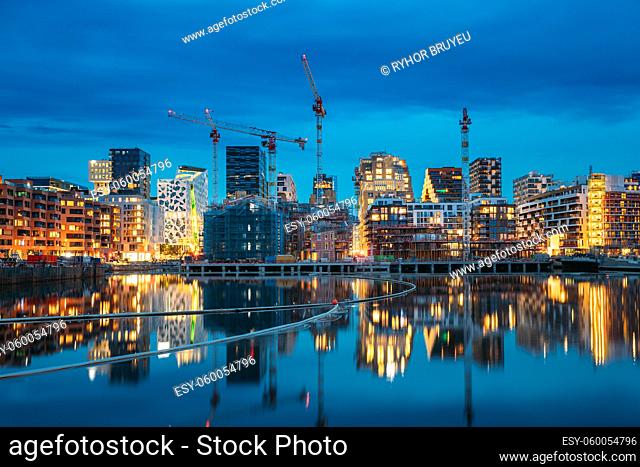 Oslo, Norway. Night View Embankment And Residential Multi-storey House In Gamle Oslo District. Summer Evening. Residential Area Reflected In Sea Waters