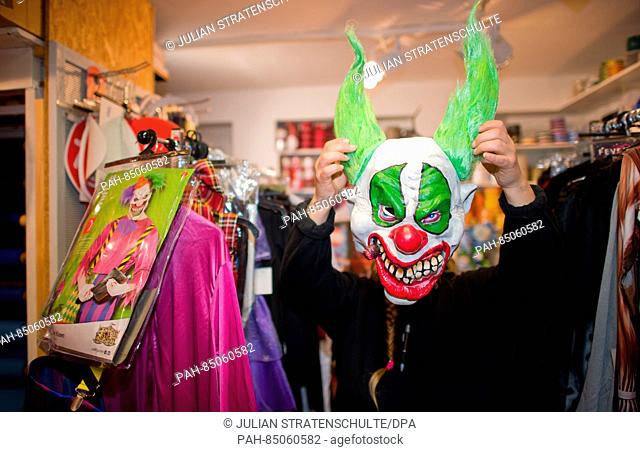 A salesperson shows off a clown mask at 'Lutzmann Berger & Traupe, ' a specialty store for costumes and theatrical supplies in Hanover, Germany, 25 October 2016
