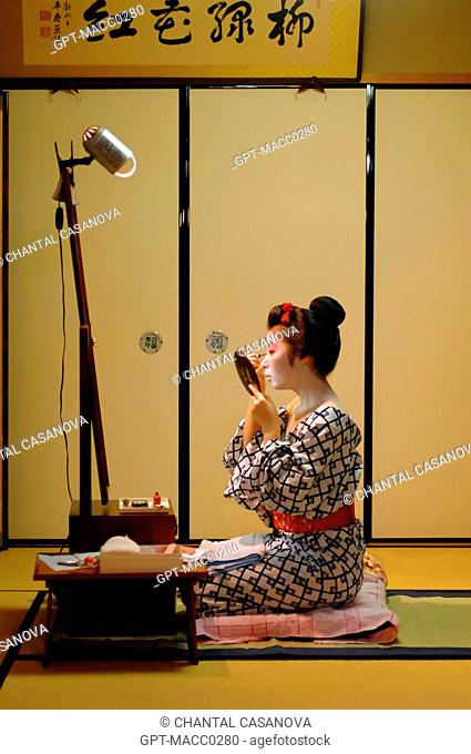 A MAIKO APPRENTICE GEISHA WITH HER TRADITIONAL MAKEUP DORAN. APPLICATION OF A WHITE FOUNDATION SHIRONURI WITH A BAMBOO BRUSH BURASHI