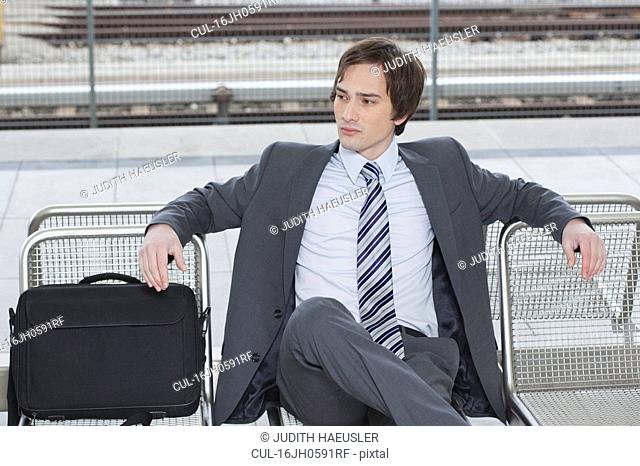 businessman sitting on bench, waiting