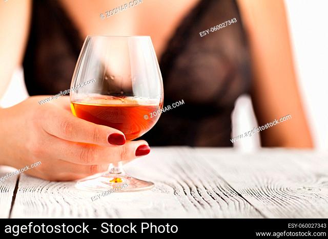 Female hand holding a glass of cognac