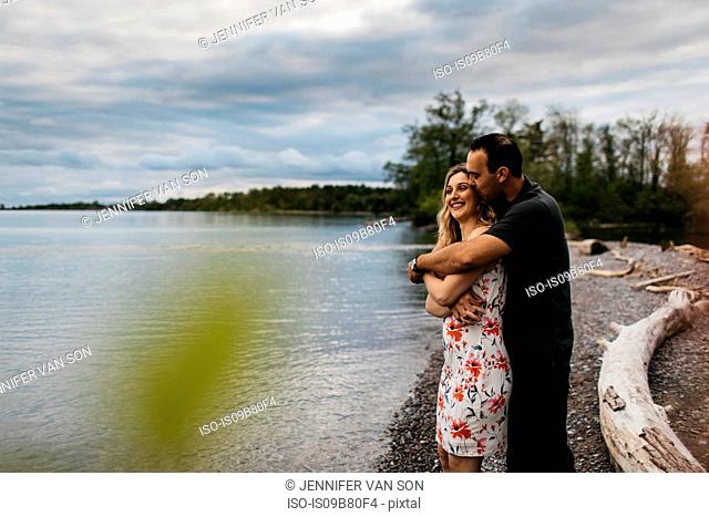 Romantic couple hugging on beach, Oshawa, Canada