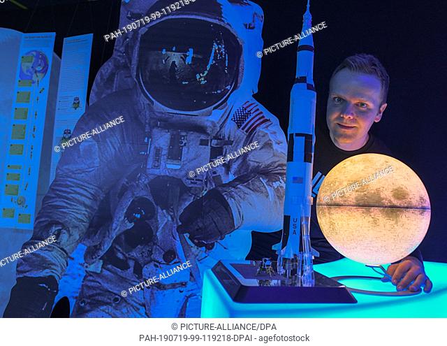 17 July 2019, Brandenburg, Eberswalde: Benjamin Stöwe, owner of the Star Trek Museum ""Spaceship Eberswalde"", stands behind a globe of the moon and a model of...