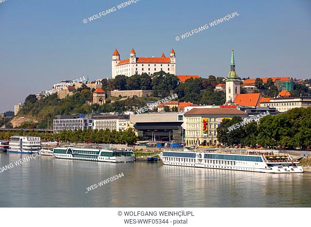 Slovakia, Bratislava, Cruise ships moored on Danube river and Bratislava Castle
