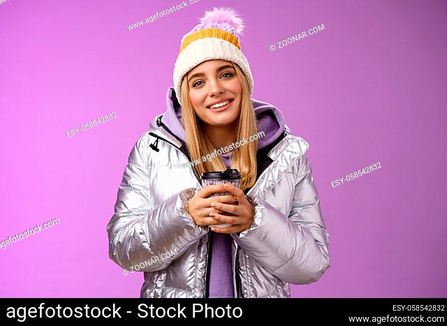 Tender relaxed cheerful smiling blond girl look pleased relieved drinking hot coffee cacao enjoying nice heartwarming moment look camera delighted gentle grin