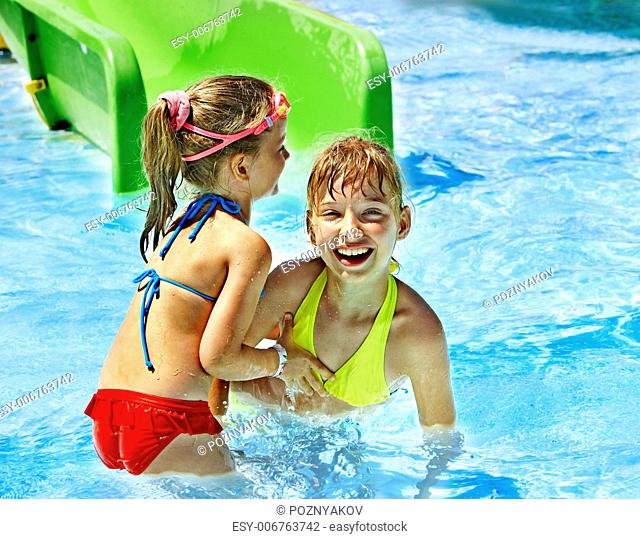 Children on water slide at aquapark. Summer holiday