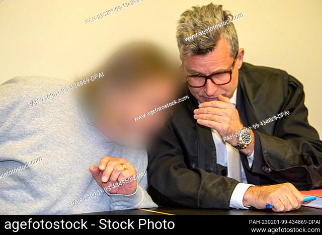 01 February 2023, Bavaria, Augsburg: The defendant (l) speaks in the Criminal Justice Center with his lawyer Detlev Binder (r) in the dock