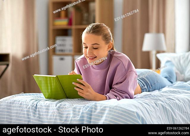 girl lying on bed and writing to diary at home