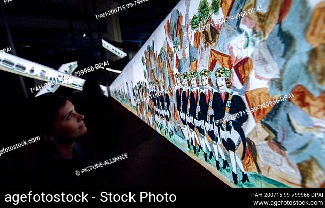 10 July 2020, Saxony, Zwickau: In the central exhibition of the 4th Saxon State Exhibition, a woman looks at a representation of the so-called Saturn Festival...