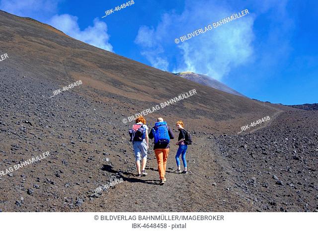 Hikers climbing through volcanic landscape, Volcano Etna, Province of Catania, Silzilia, Italy