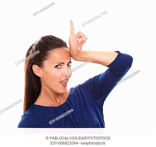 Pretty lady in blue blouse pointing up while looking at you in white background - copyspace