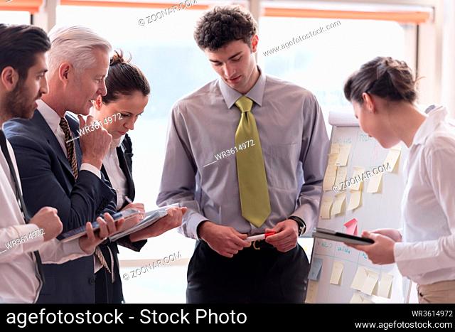 young startup businessman making presentation of project to senior investior, group of business people taking notes and make plans on white flip board and...