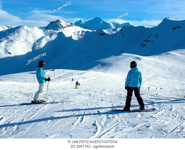 two girls with snowboards and ski's at skipiste in Flaine, France