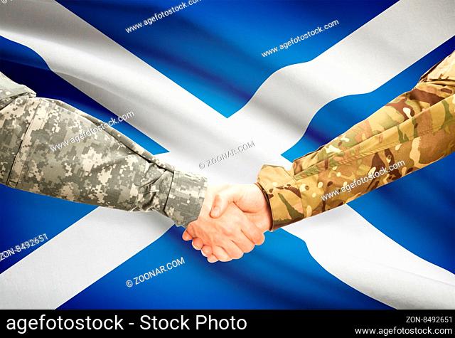 Soldiers shaking hands with flag on background - Scotland