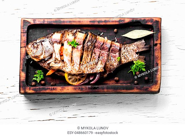Grilled whole fish loaded with citrus, vegetable and spices in baked fish