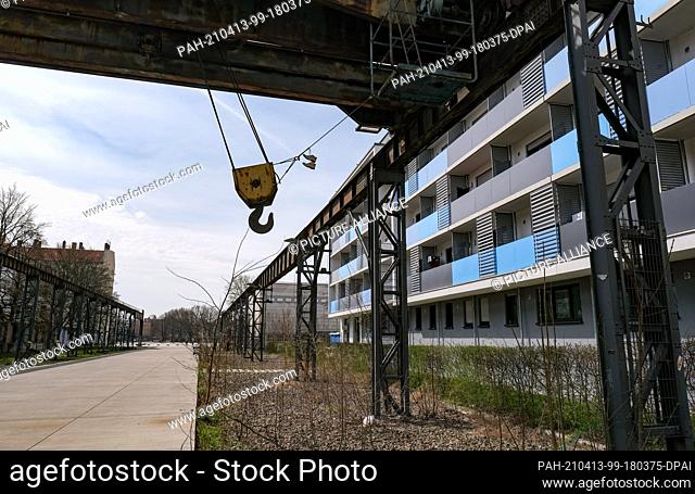 09 April 2021, Berlin: A path beneath the remains of a disused crane runway in Berlin-Oberschöneweide leads from Wilhelminenhofstraße to a town square with a...
