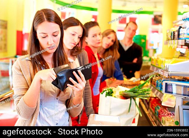 Frau sucht ihr Geld zusammen an der Supermarktkasse