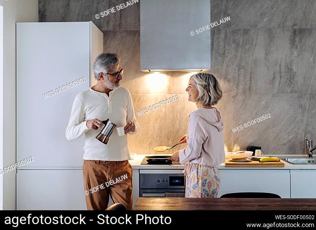 Mature couple in kitchen at home in the morning