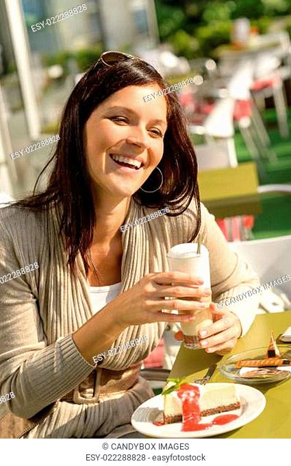 Woman at cafe bar holding latte drink