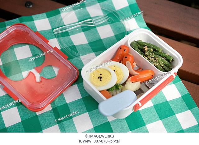 High angle view of an opened lunchbox on the napkin with foodstuff kept in it