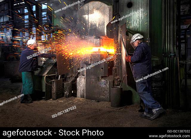 Sparks fly as counterblow hammer forms flight bar, the counterblow hammer forges by striking from both above and below mining component