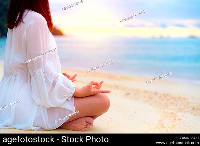 Asian young woman practice yoga on the beach near the sea under sunlight at sunrise, Relaxation for health in the midst of nature with happiness and peace