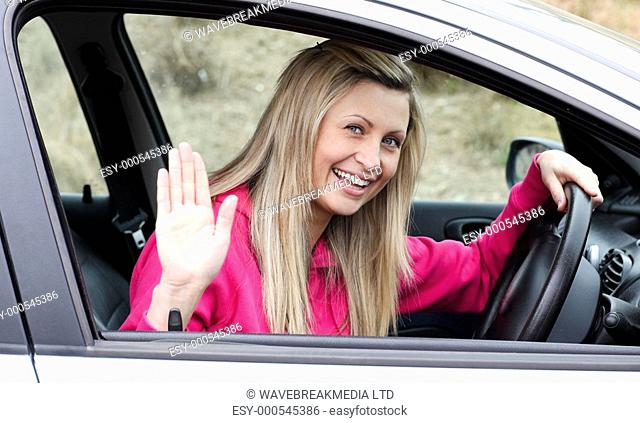 Joyful young female driver at the wheel in her new car